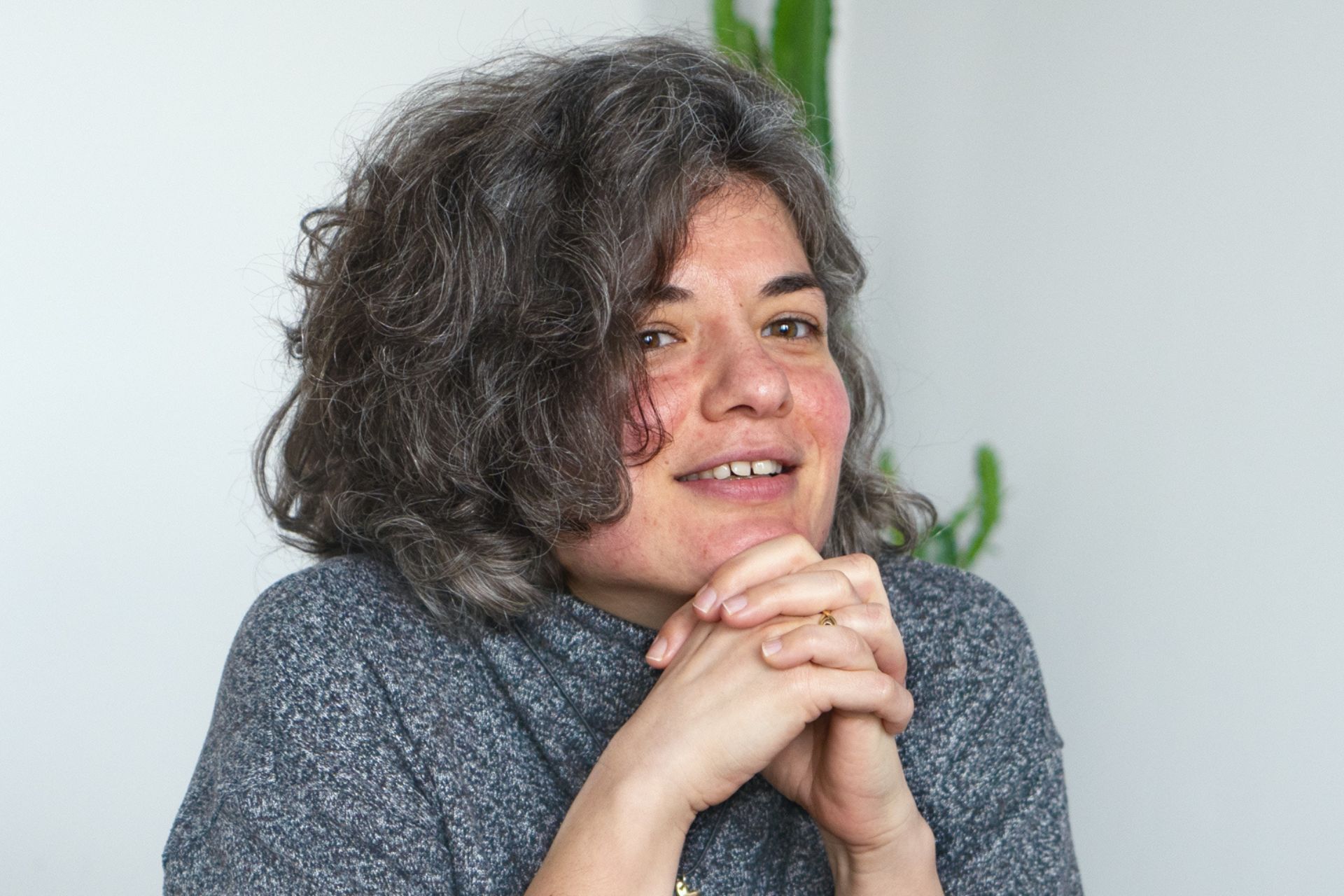 Jana beim DigitalService sitzt an einem Tisch und schaut in die Fotokamera