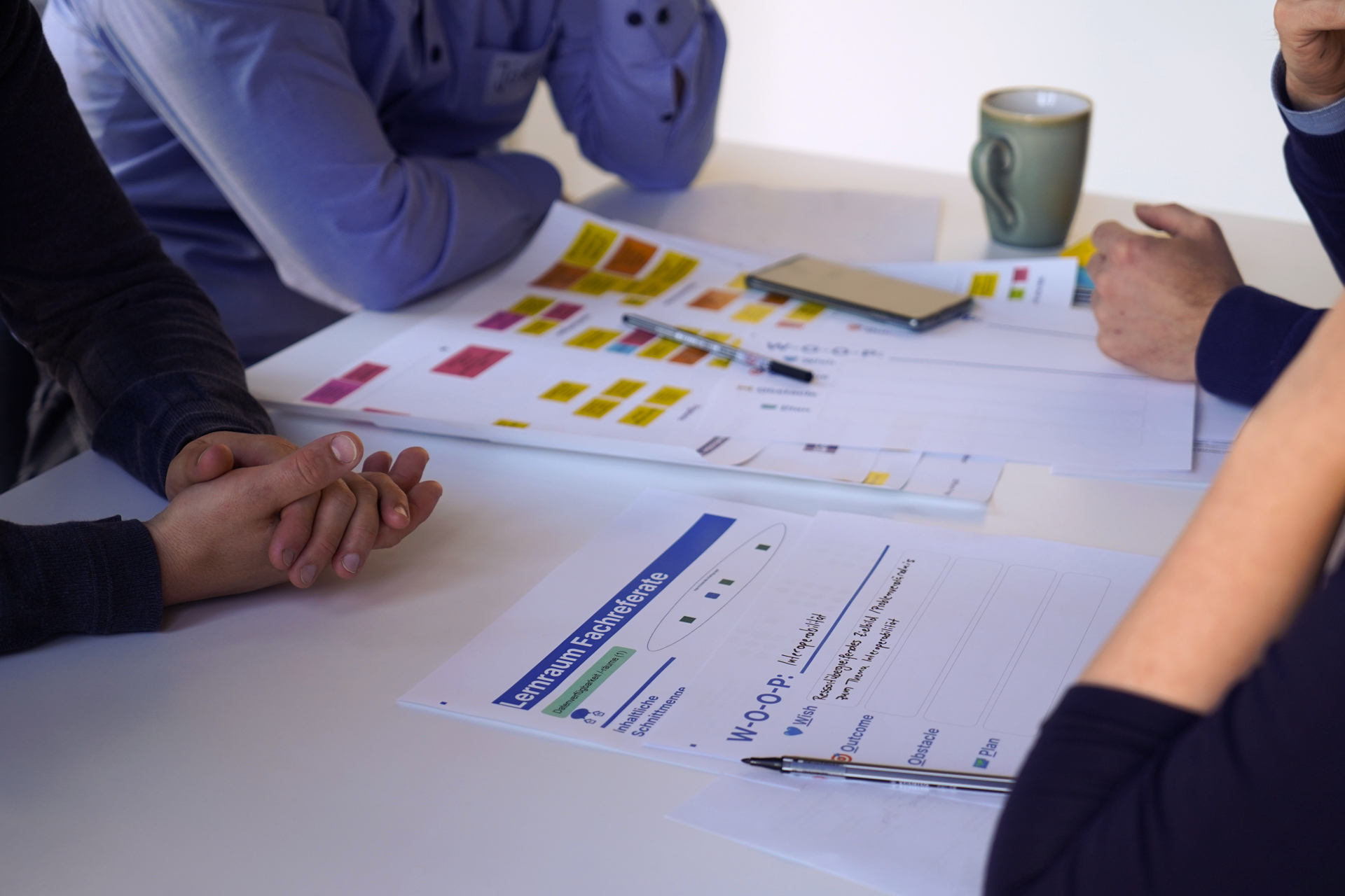 Eine Gruppe Personen sitzt an einem Tisch und diskutiert