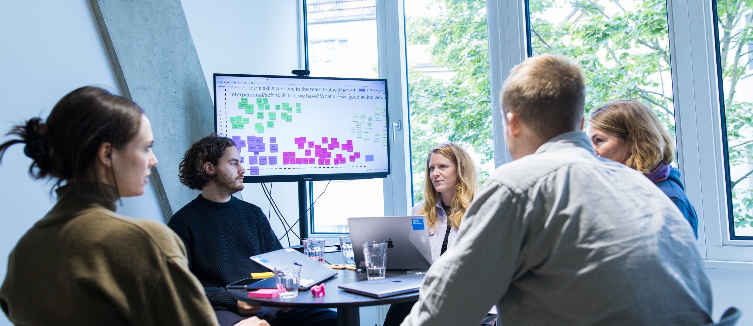 mehrere Personen in einem Gespräch an einem Tisch