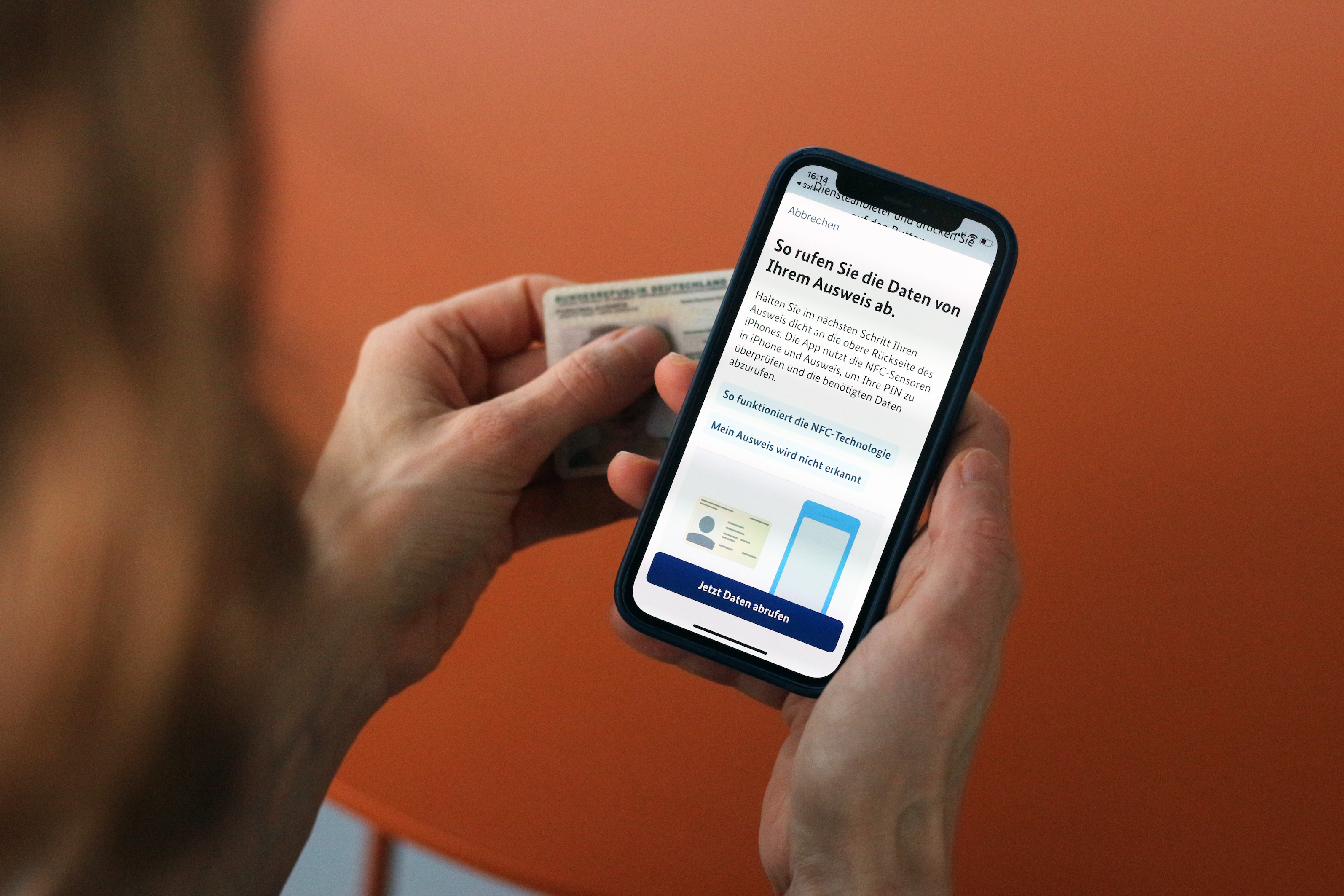 Eine Person hält im Verlauf des Identifizierungsprozesses mit BundesIdent ihren Personalausweis, sowie ihr Mobiltelefon mit der geöffneten Anwendung in den Händen.