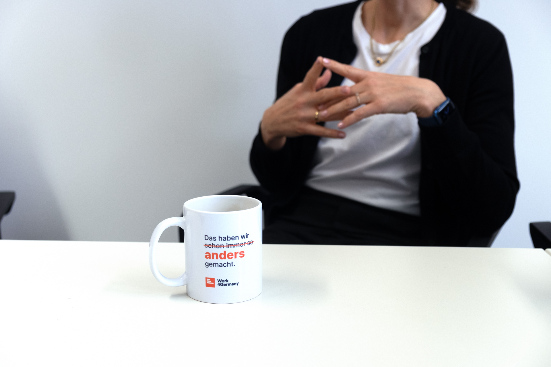 Auf einem Tisch steht vor Interviewpartnerin Julia eine Work4Germany Tasse