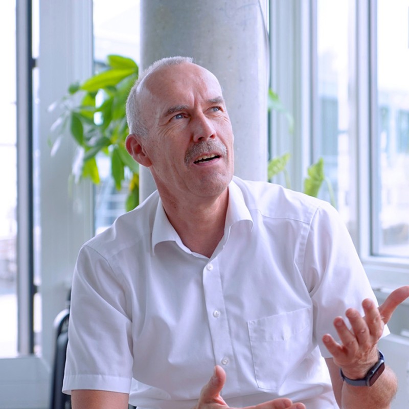 Jörg sitzt gestikulierend auf einer Couch im DigitalService Büro