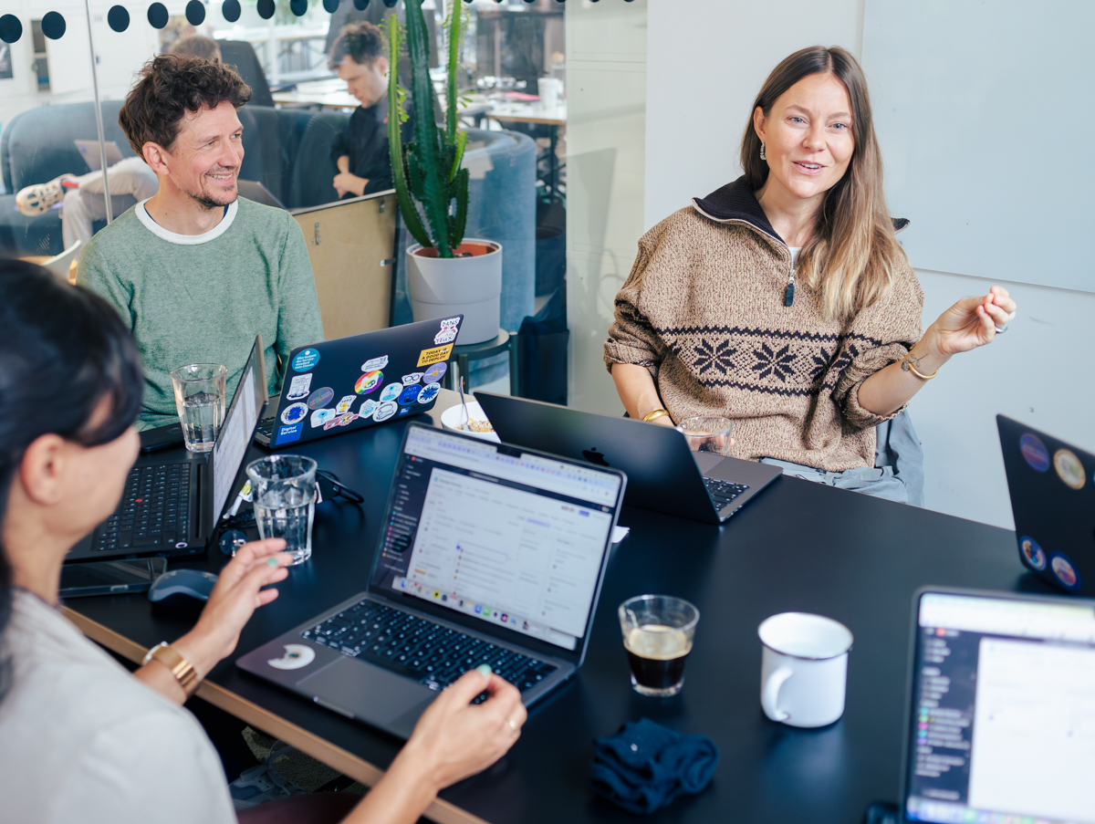 Mitarbeitende des DigitalService sitzen gut gelaunt und diskutierend in einem Meetingraum