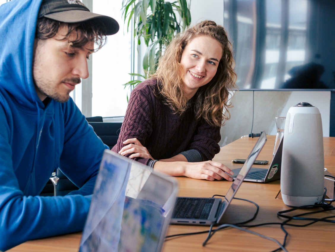 Ein Mann und eine Frau sitzend im Büro an Computern.
