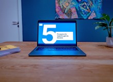 Ein Laptop steht geöffnet auf einem Schreibtisch; auf dem Bildschirm ist die Folie einer Präsentation zu sehen auf der „5 Prinzipien für digitaltaugliche Gesetze“ steht