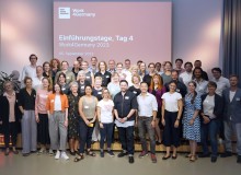 Alle Teilnehmenden des 4. Work4Germany Jahrgangs stehen zusammen auf einer Bühne