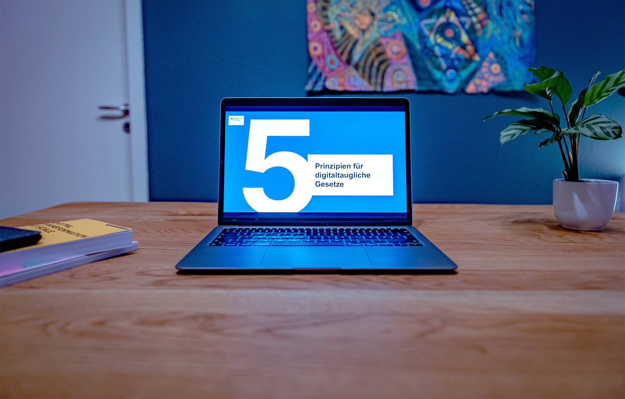 A laptop is open on a desk; the screen shows a slide from a presentation entitled “5 principles for digital laws”.
